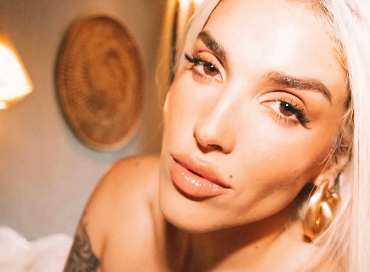 Close-up portrait of an artist with gold earrings and glowing skin