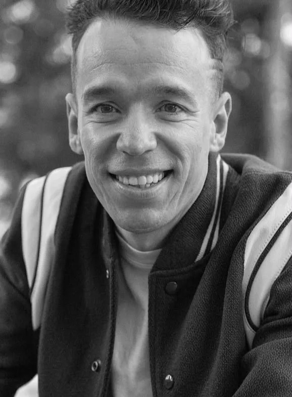 Black and white portrait of an artist in a varsity jacket