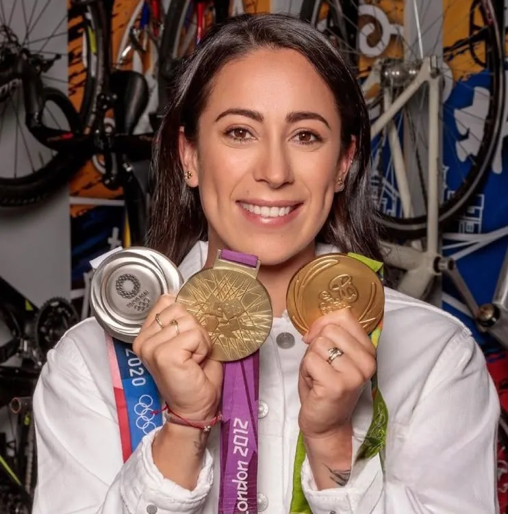 Athlete posing with her Olympic medals