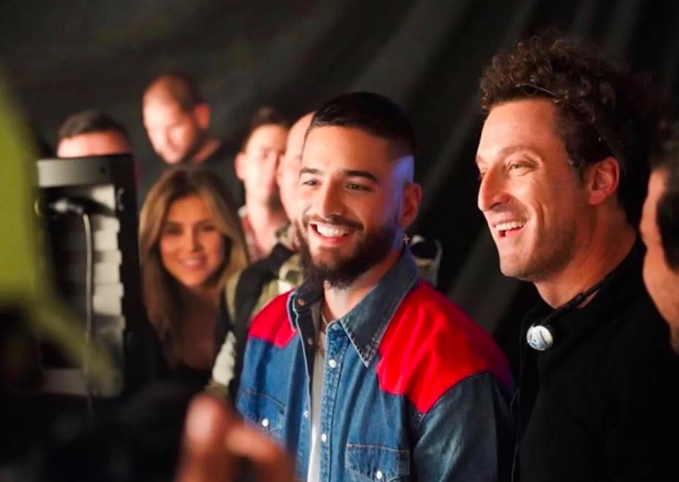 Artist smiling with the production crew in front of the monitor