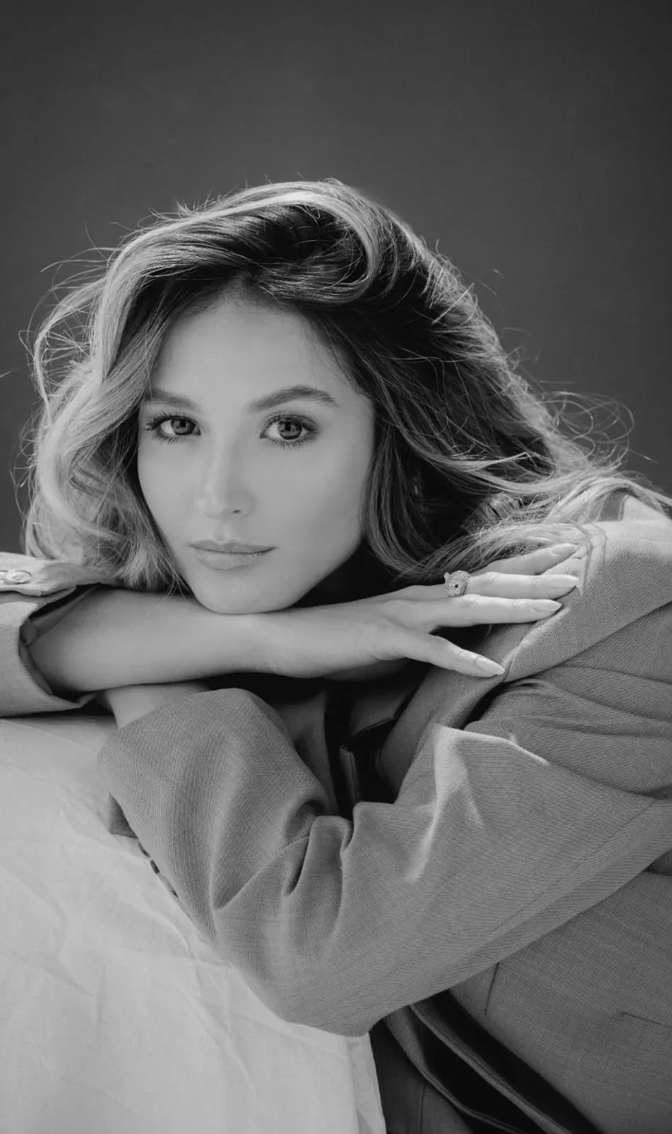 Black and white editorial portrait of a model in a blazer, shot in studio