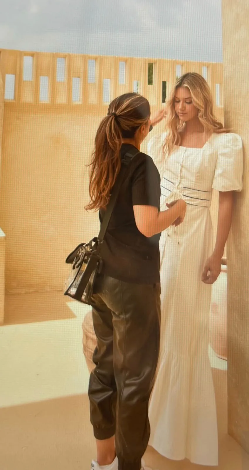 Touching up the model's makeup during the shoot, on a sand-toned set
